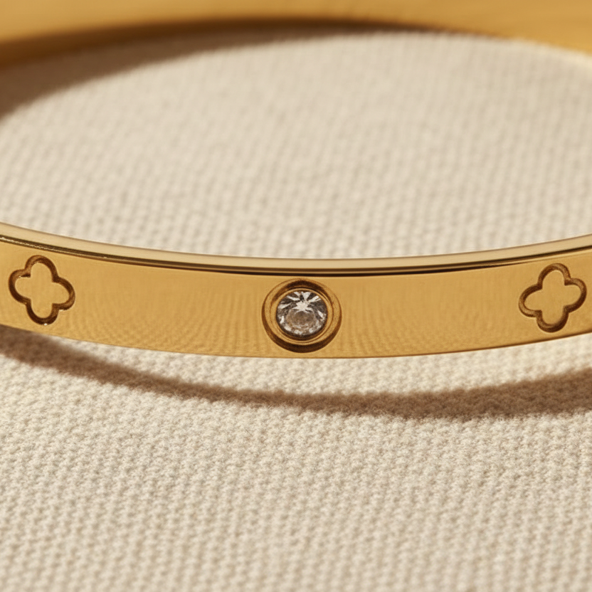 Close-up of gold bangle with alternating stone and clover