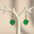 Four-leaf clover earrings on light background